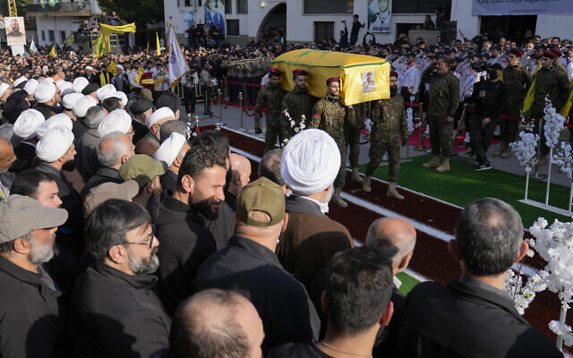 Des membres du groupe terroriste chiite libanais du Hezbollah portant le cercueil de Wissam al-Tawil, commandant en chef du groupe, lors de ses funérailles dans le village de Khirbet Selm, au Sud-Liban, le 9 janvier 2024. (Crédit : Hussein Malla/AP)