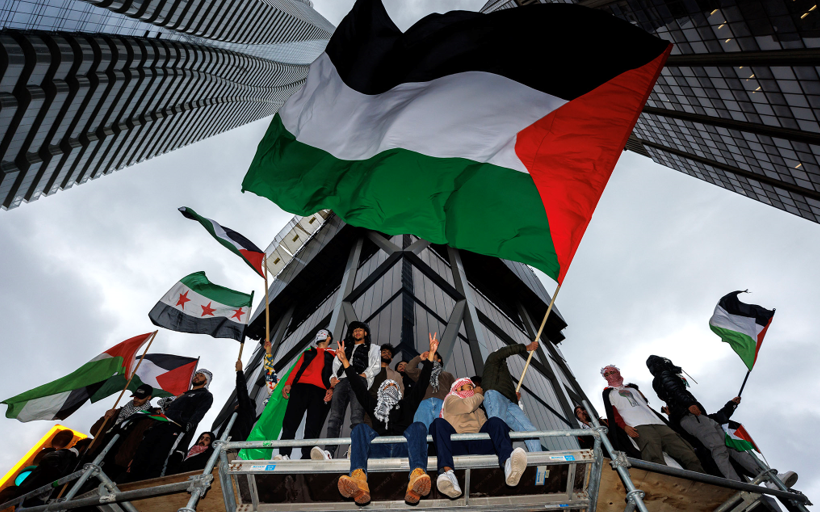 Des manifestants anti-Israël brandissent des drapeaux palestiniens lors d'une manifestation à Toronto (Canada), le 9 octobre 2023. (Crédit : Cole Burston / AFP)