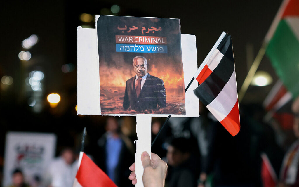 Un Koweïtien tient une pancarte portant le portrait du Premier ministre israélien Benjamin Netanyahu lors d'un rassemblement de solidarité avec la population de Gaza sur la place Iradah à Koweït City, le 14 janvier 2024. (Crédit : YASSER AL-ZAYYAT / AFP)