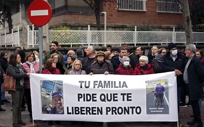 Des manifestants tiennent une banderole sur laquelle on peut lire "Ta famille demande ta libération immédiate" lors d'un rassemblement demandant la libération de Santiago Sanchez Cogedor, près de l'ambassade d'Iran à Madrid, le 18 décembre 2022. (Crédit : THOMAS COEX / AFP)