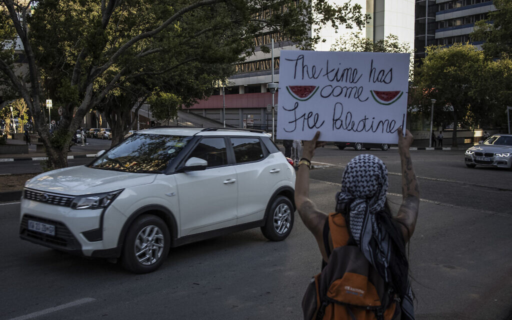 Un activiste pro-palestinien tient un panneau avec des images de tranches de pastèque à Johannesburg, en Afrique du sud, le 24 novembre 2023. (Crédit : Davide Longari/AFP)