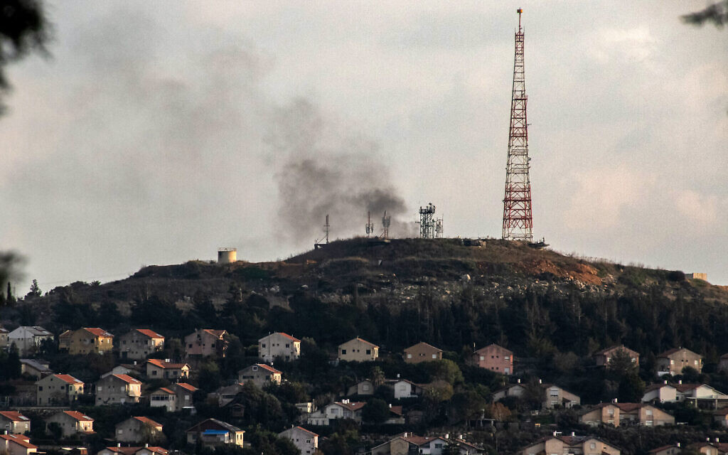 De la fumée s'échappant de la frontière au nord d'Israël à proximité d'une installation militaire à Metula, après que le groupe terroriste libanais du Hezbollah a lancé une salve de roquettes, sur une photo prise depuis le sud du Liban, le 31 décembre 2023. (Crédit : Hasan Fneich/AFP