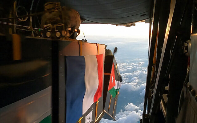 Cette photo publiée par le bureau de presse des forces armées jordaniennes le 5 janvier 2024 montre des cartons d'aide humanitaire franco-jordanienne largués d'un avion cargo militaire lors de largages au-dessus de Khan Younès et d'un hôpital de campagne jordanien dans la bande de Gaza (Crédit : Forces armées jordaniennes /AFP)