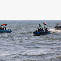 Des membres des garde-côtes yéménites affiliés aux Houthis patrouillant en mer avec des drapeaux palestiniens alors que des manifestants défilent dans la ville portuaire de Hodeida, sur la mer Rouge, en solidarité avec la population de Gaza, le 4 janvier 2024. (Crédit : AFP)