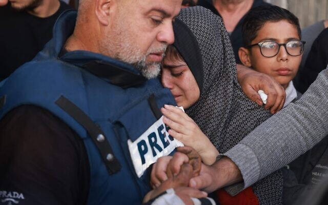 Le journaliste d'Al Jazeera Wael Dahdouh consolant sa fille et tenant la main de son fils Hamza, qui travaillait également pour Al-Jazeera et qui a été tué lors d'une attaque aérienne israélienne à Rafah, dans la bande de Gaza, le 7 janvier 2024. (Crédit : AP Photo/Hatem Ali)