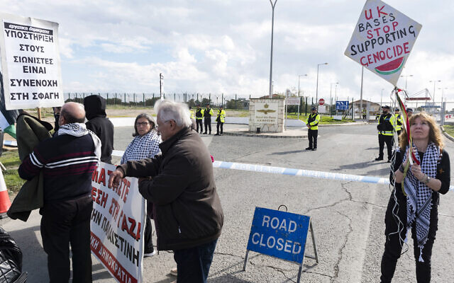 Des manifestants se rassemblent devant les portes de la base de la Royal Air Force à Akrotiri, un territoire britannique d'outre-mer près de la ville côtière chypriote de Limassol, alors qu'ils protestent contre son utilisation présumée pour approvisionner la guerre d'Israël à Gaza, une accusation démentie par la Grande-Bretagne, le 14 janvier 2024. (Crédit : Iakovos Hatzistavrou / AFP)