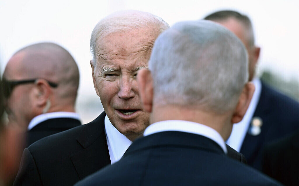Le Premier ministre Benjamin Netanyahu (à l'arrière) accueille le président américain Joe Biden à son arrivée à l'aéroport international Ben Gurion, le 18 octobre 2023. (Crédit : Brendan Smialowski/AFP)