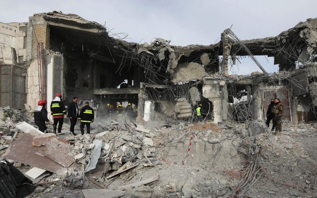 Une équipe de défense civile mène des opérations de recherche et de secours dans un bâtiment endommagé suite à une frappe au missile lancée par le Corps des gardiens de la révolution à Erbil, en Irak, le 17 janvier 2024. (Crédit : Safin HAMID / AFP)