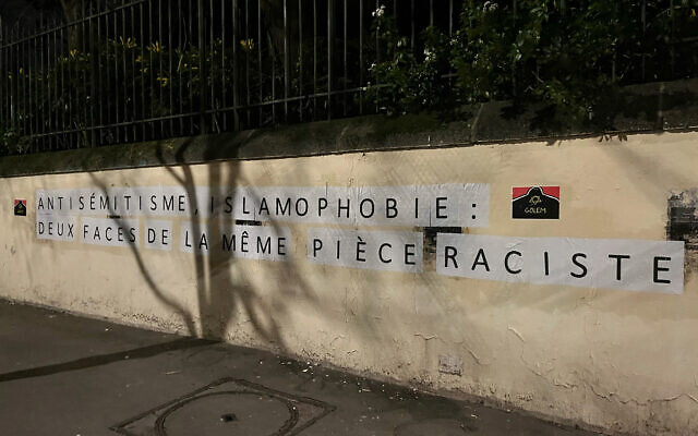 Un slogan collé sur un mur par les membres du collectif antiraciste de juifs de gauche "Golem", qui dit "Antisémitisme, islamophobie : les deux faces d'une même pièce raciste", dans le
centre de Paris, le 21 janvier 2024. (Crédit : Antoine Boyer/AFP)