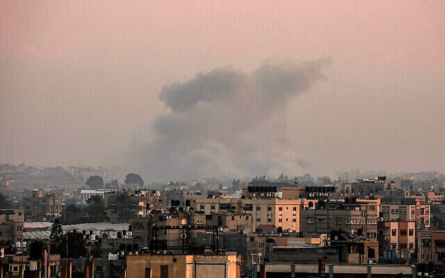 Une colonne de fumée s'élève au-dessus de Khan Younès, dans le sud de la bande de Gaza, pendant des frappes israéliennes, vue depuis Rafah, le 23 janvier 2024. (Crédit : AFP)