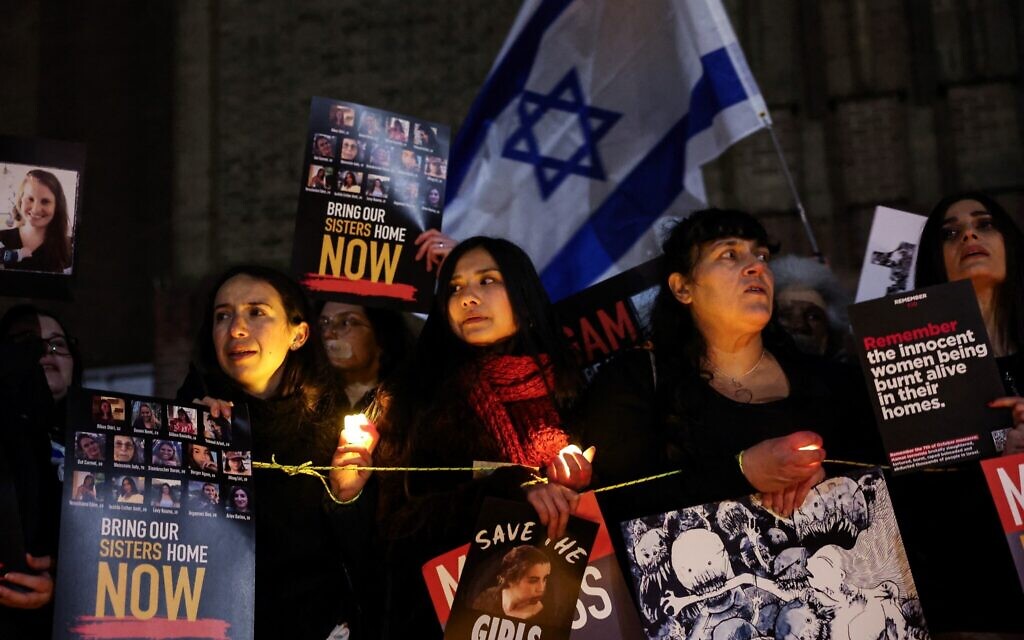 Des femmes brandissent des panneaux en participant à une manifestation "Save our Girls" aux abords du musée d'art Tate Modern pour dénoncer la situation des femmes retenues par les terroristes du Hamas dans la bande de Gaza, le 26 janvier 2024. (Crédit : Daniel LEAL / AFP)