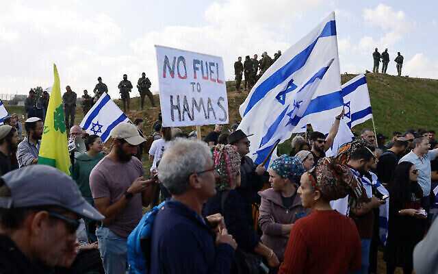 Des manifestants israéliens, dont des parents d'otages détenus à Gaza depuis l'attaque du 7 octobre par le Hamas, lors d'une manifestation visant à bloquer l'entrée des camions d'aide dans le territoire palestinien, du côté israélien du poste frontière de Kerem Shalom avec le sud de la bande de Gaza, le 29 janvier 2024. (Crédit : Menahem Kahana / AFP)