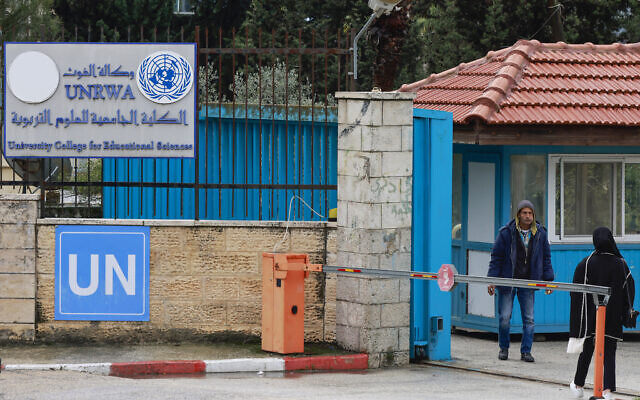 Des Palestiniens se tiennent à l'entrée du Collège universitaire des sciences de l'éducation géré par l'UNRWA à Ramallah, en Cisjordanie, le 29 janvier 2024. (Crédit : Jaafar Ashtiyeh/AFP)