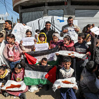 Des Palestiniens, hommes et enfants, manifestent à Rafah, dans le sud de Gaza, réclamant le soutien continu de la communauté internationale à l'Office de secours et de travaux des Nations unies pour les réfugiés de Palestine dans le Proche-Orient, l'UNRWA, le 30 janvier 2024. (Crédit : AFP)