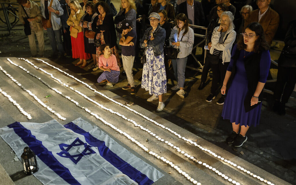 Des membres de la communauté juive allumant des bougies quatre jours après que les terroristes du Hamas ont lancé un massacre sans précédent et sur plusieurs fronts contre Israël, qui a fait plus de 1 200 morts, devant la synagogue de Strasbourg, en France, le 11 octobre 2023. (Crédit : Jean-Francois Badias/AP Photo)