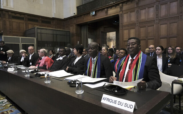 L'ambassadeur de l'Afrique du sud aux Pays-Bas, Vusimuzi Madonsela, à droite, et le ministre de la Justice et des Services correctionnels sud-africains, Ronald Lamola, au centre, à l'ouverture de l'une des audiences de la Cour internationale de Justice de La Haye, aux Pays-Bas, le 11 janvier 2024. (Crédit : AP Photo/Patrick Post)