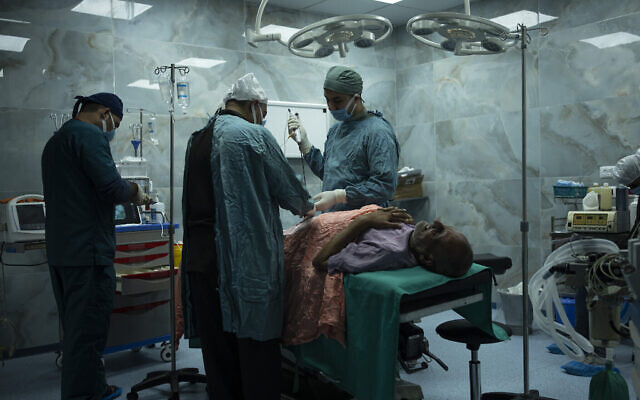 Dr. Suhaib Alhamss, le directeur de l'Hôpital Koweïtien dans la ville du sud de Rafah à Gaza, effectue une intervention chirurgicale sur un patient, le 11 janvier 2024. (Crédit : AP/Fatima Shbair)
