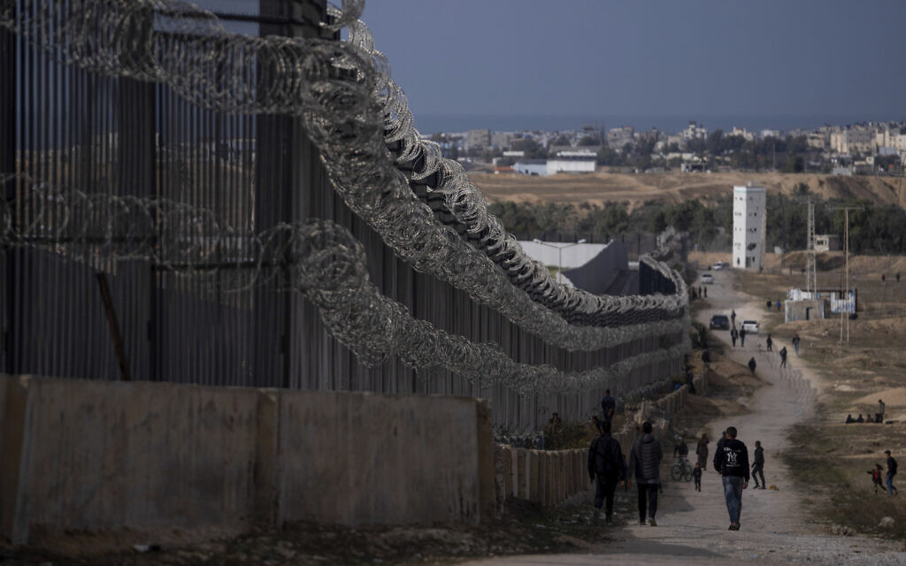 Des Palestiniens déplacés par les frappes israéliennes contre le Hamas sur la bande de Gaza marchent près de la frontière avec l'Égypte, à Rafah, dans le sud de la bande de Gaza, le 14 janvier 2024. (Crédit : AP Photo/Fatima Shbair)