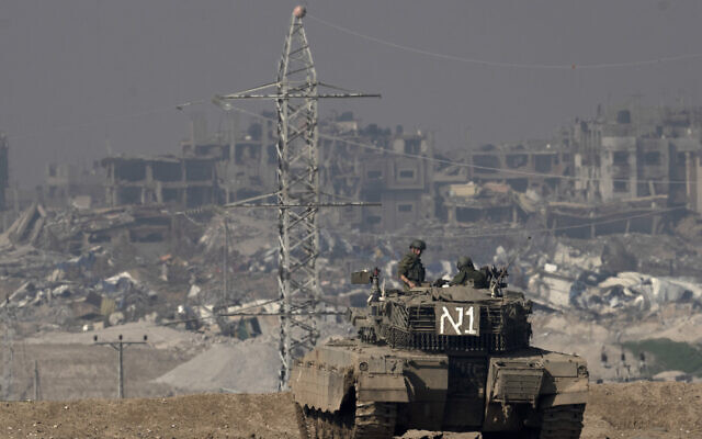 Des soldats israéliens surplombant la bande de Gaza depuis un char d'assaut, dans le sud d'Israël, le 19 janvier 2024. (Crédit : Maya Alleruzzo/AP Photo)