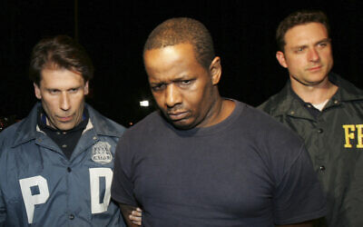 James Cromitie, au centre, escorté par des officiers de police hors d'un bâtiment fédéral après avoir été arrêté pour des accusations liées à un projet d'attentat à la bombe dans le Bronx, le 21 mai 2009, à New York. (Crédit : Robert Mecea/AP)