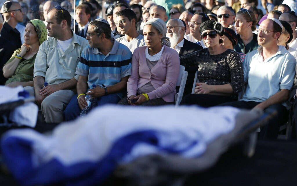 Les parents de Naftali Fraenkel, 16 ans, Eyal Yifrah, 19 ans, et Gilad Shaer, 16 ans, de gauche à droite, les trois adolescents israéliens qui ont été enlevés et tués en Cisjordanie, pendant les funérailles communes de leurs fils, à Modiin, le 1er juillet 2014. (Crédit : Baz Ratner/AP/Pool)