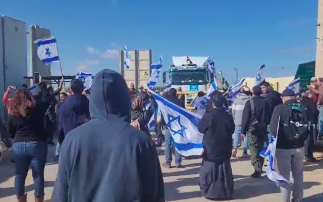 Des Israéliens manifestent lors d'une action de protestation au poste-frontière de Kerem Shalom, le 24 janvier 2024. (Crédit : Reut Ben Haim)
