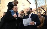Elon Musk, avec son fils X Æ A-Xii sur ses épaules, parle avec le rabbin Menachem Margolin au musée d’Auschwitz-Birkenau, en Pologne le 22 janvier 2024. (Crédit : Yoav Dudkevitch)