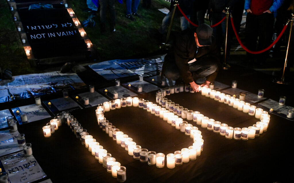 Un homme allumant des bougies pour marquer les 100 jours depuis le début de la guerre lors d'une manifestation contre le Premier ministre israélien Benjamin Netanyahu et le gouvernement israélien actuel, à Tel Aviv, le 13 janvier 2024. (Crédit : Avshalom Sassoni/Flash90)