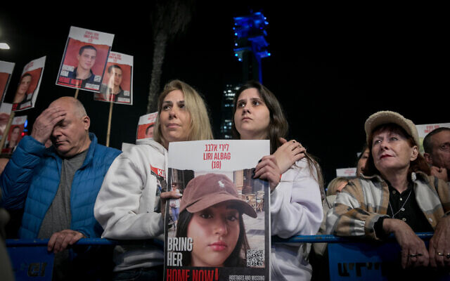 Shira Albag, deuxième à gauche et sa fille Shai brandissant une photo de Liri Albag sur la "Place des Otages", à Tel Aviv, le 20 janvier 2024. (Crédit : Miriam Alster/Flash90)