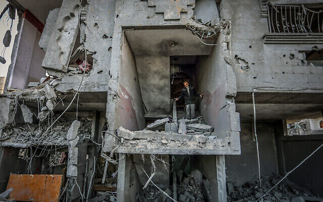 Des Palestiniens près d'un bâtiment détruit par une frappe aérienne israélienne à Rafah, dans le sud de la bande de Gaza, le 25 janvier 2024. (Crédit : Abed Rahim Khatib/Flash90)
