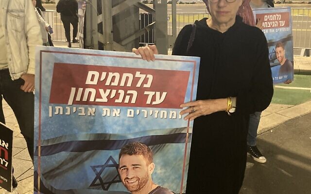 Ditza Or tient une photo de son fils Avinatan, retenu en otage à Gaza, devant le quartier général militaire de Kirya à Tel Aviv, le 27 décembre 2023. (Mati Wagner)
