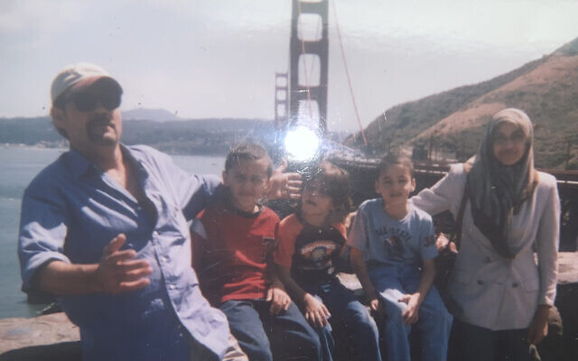 Abedalla Sckak, mort à Gaza, avec ses enfants et son épouse Zahra Sckak, qui a pu quitter l’enclave, sur une vieille photo de famille à San Francisco. (Crédit : Fadi Sckak via AP)