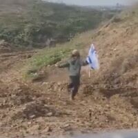 L'un des deux jeunes enfants israéliens parvenu à se glisser sous la clôture frontalière de Gaza, se dirigeant vers la bande en transportant un drapeau israélien, le 25 janvier 2024. (Capture d'écran/used in accordance with Clause 27a of the Copyright Law)