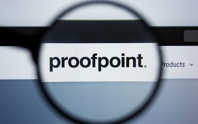 Le logo de Proofpoint vu à travers une loupe sur un écran montrant le site web de l'entreprise Illustration (Crédit : II.studio/Shutterstock.com)