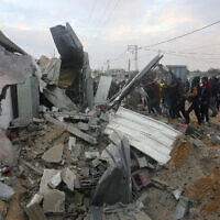 Des Palestiniens regardent une maison détruite par une frappe israélienne à Rafah, dans la bande de Gaza, le 5 février 2024. (Crédit : Hatem Ali/AP)