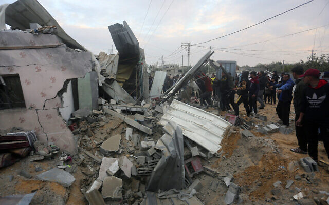 Des Palestiniens regardent une maison détruite par une frappe israélienne à Rafah, dans la bande de Gaza, le 5 février 2024. (Crédit : Hatem Ali/AP)