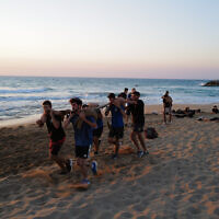 De jeunes Israéliens participent à un programme de préparation à l'armée sur la plage de Nahariya, le 8 septembre 2022 (Crédit : Michael Giladi/Flash90)