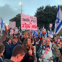 Des manifestants sont rassemblés devant la Knesset pour protester contre le budget de guerre 2024 du gouvernement, le 19 février 2024. (Crédit : Charlie Summers/Times of Israel)