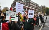 Des manifestants tiennent des pancartes sur lesquelles on peut lire un message destiné au leader travailliste britannique Keir Starmer, appelant à un cessez-le-feu dans le conflit entre Israël et le Hamas, devant son bureau lors de la "Journée d'action pour la Palestine", une marche de Chalk Farm à Camden Town, à Londres, le 18 novembre 2023. (Crédit : JUSTIN TALLIS / AFP)