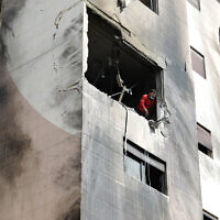 Un homme vérifie les dégâts dans un appartement d'un immeuble résidentiel qui aurait été visé par des frappes aériennes israéliennes dans le quartier de Kafr Sousa de la capitale syrienne Damas, le 21 février 2024. (Crédit : LOUAI BESHARA / AFP)