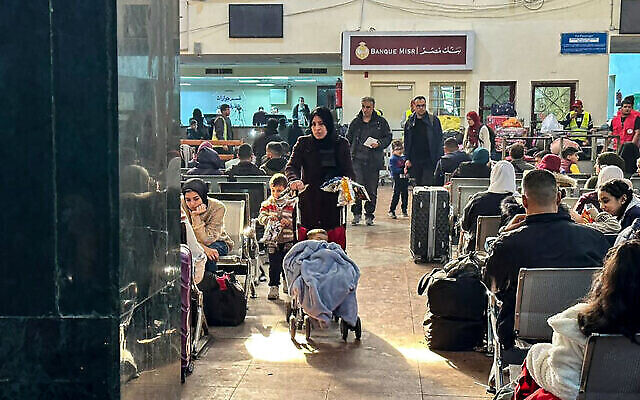 Illustration : Des Palestiniens attendant au poste-frontière de Rafah, en Égypte, après avoir été évacués de la bande de Gaza, le 26 décembre 2023. (Crédit : AFP)