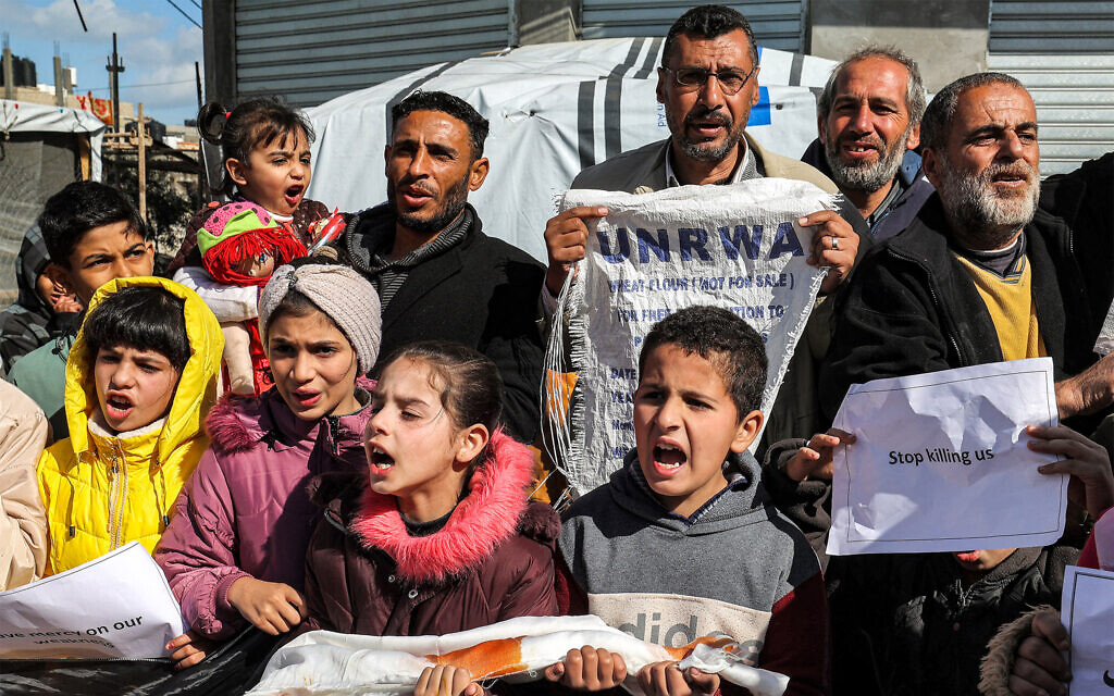 Des Palestiniens manifestant pour demander le maintien du soutien international à l'Office de secours et de travaux des Nations unies pour les réfugiés de Palestine dans le Proche-Orient (UNRWA), à Rafah, dans le sud de la bande de Gaza, le 30 janvier 2024. (Crédit : AFP/Dossier)