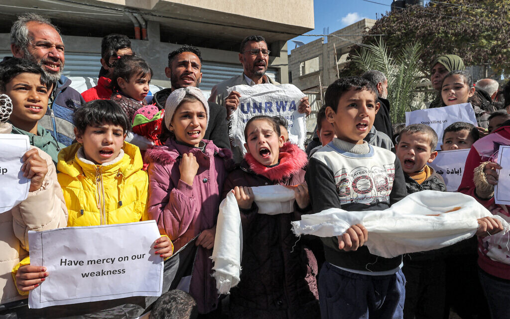 Des manifestants palestiniens appelant à la poursuite du soutien international à l'Office de secours et de travaux des Nations unies pour les réfugiés de Palestine dans le Proche-Orient (UNRWA), à Rafah, dans le sud de la bande de Gaza, le 30 janvier 2024. (Crédit : AFP)