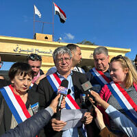 Le député français La France insoumise Eric Coquerel (au centre) lit une déclaration entouré d'une délégation de parlementaires français exigeant un cessez-le-feu entre Israël et le Hamas, lors d'une visite au poste-frontière de Rafah, au nord-est du Sinaï, le 4 février 2024. (Crédit : AFP)