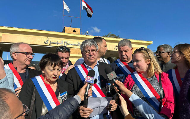 Le député français La France insoumise Eric Coquerel (au centre) lit une déclaration entouré d'une délégation de parlementaires français exigeant un cessez-le-feu entre Israël et le Hamas, lors d'une visite au poste-frontière de Rafah, au nord-est du Sinaï, le 4 février 2024. (Crédit : AFP)