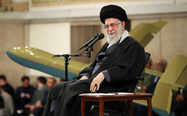 L'ayatollah Ali Khamenei, assis sur scène lors d'une réunion avec les commandants de l'armée de l'air iranienne à Téhéran, le 5 février 2024, avec un drone local Kaman-12 derrière lui. (Crédit : khamenei.ir/AFP)
