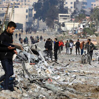 Des gens marchent dans une rue détruite par les bombardements israéliens dans la ville de Gaza, le 10 février 2024. (Crédit : AFP)