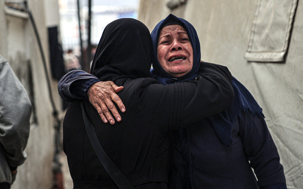 Des Palestiniennes pleurent après avoir identifié les corps de proches tués dans des bombardements israéliens dans le sud de la bande de Gaza, à l'hôpital Al-Najjar de Rafah, le 10 février 2024. (Crédit :  Said Khatib/AFP)