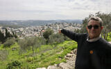 Le maire du village israélo-arabe d'Abou Gosh, Saleem Jaber, faisant un geste en direction des bâtiments, le 13 février 2024. (Crédit : Ahamad Gharabli/AFP)