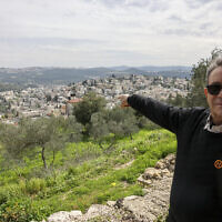 Le maire du village israélo-arabe d'Abou Gosh, Saleem Jaber, faisant un geste en direction des bâtiments, le 13 février 2024. (Crédit : Ahamad Gharabli/AFP)